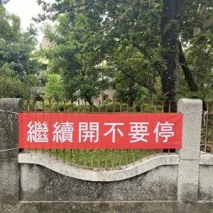 一面紅布條，上面印有繼續開不要停等字樣