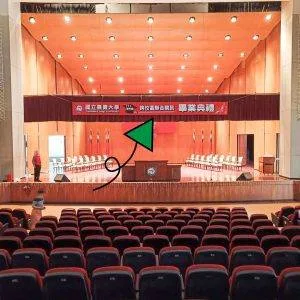 舞臺上綁著111年度畢業典禮等字樣的布條